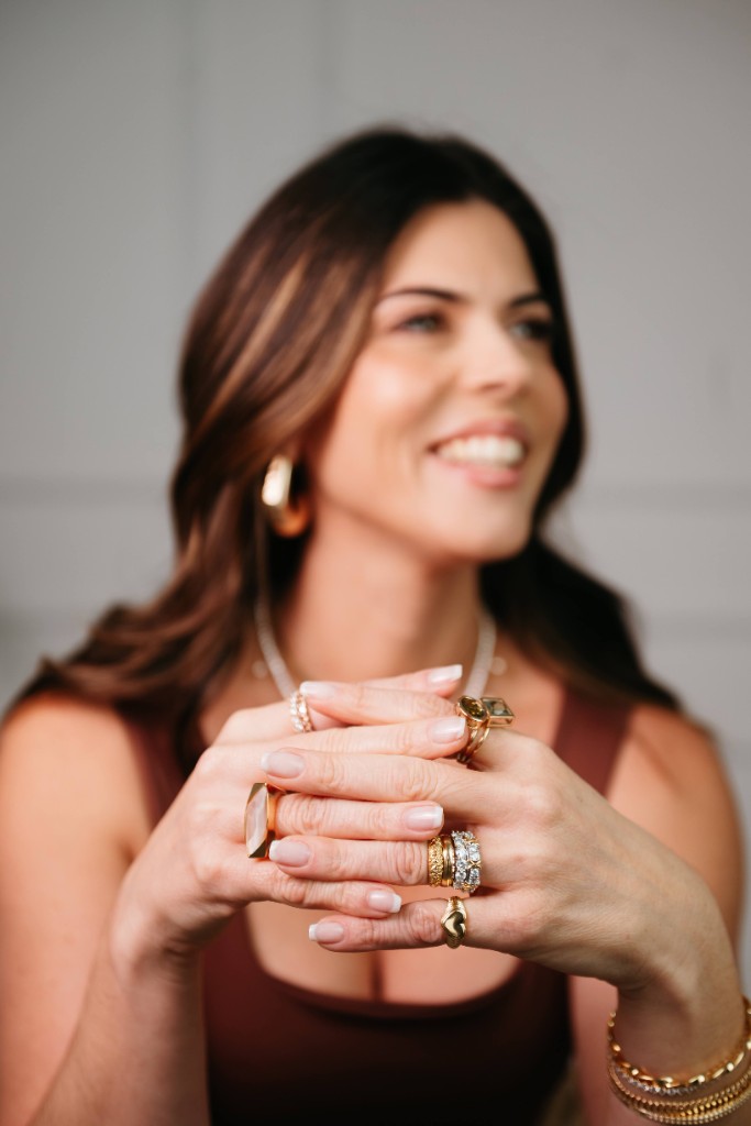 Mãos com mix de anéis dourados, pedras e pulseiras